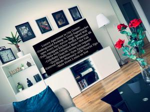 a living room with a sign on the wall at E1 Luxury OldTown Apt - 2x Parking, Foodstore, PCscreen, Netflix, Unlimited Music, Crib, BabyChair, FastWifi, Aircon in Košice