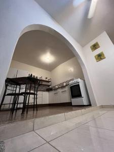 una cucina con arco, tavolo e piano cottura di Playa y Campo Studio a Isabela