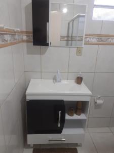 a bathroom with a white sink and a mirror at Hospedagem Alternativa Ana Nazarete in São Joaquim