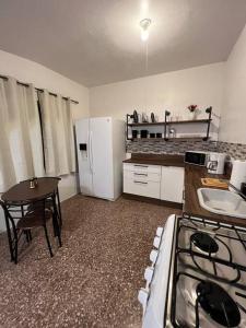 eine Küche mit einem Herd, einem Tisch und einem Kühlschrank in der Unterkunft Playa y Campo Studio in Isabela