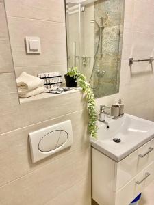 a white bathroom with a sink and a mirror at Lazar Loft in Iaşi
