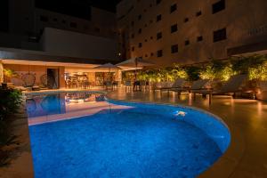 una grande piscina in un hotel di notte di Amazon Aeroporto Hotel a Cuiabá