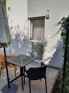 czarny stół i krzesło na patio w obiekcie Silver Lelle Apartman Balatonlelle w mieście Balatonlelle +9 zdjęć