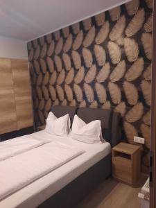 sypialnia z łóżkiem ze ścianą z piórami w obiekcie Silver Lelle Apartman Balatonlelle w mieście Balatonlelle