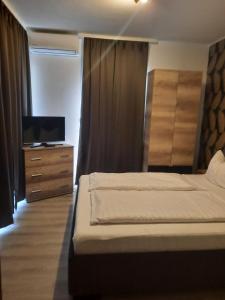 sypialnia z łóżkiem i komodą z telewizorem w obiekcie Silver Lelle Apartman Balatonlelle w mieście Balatonlelle