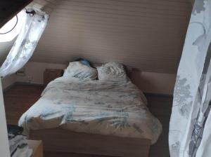 ein kleines Bett in einem Zimmer mit Fenster in der Unterkunft maison in Forest-Montiers
