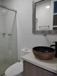 a bathroom with a sink and a toilet and a mirror at Finca La Primavera - Cabañas Campestres de Descanso in Sasaima