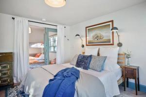 a bedroom with a large white bed with blue pillows at Quail Cottage Clarkdale-Renovated Historic Cottage Sedona Jerome Wineries in Clarkdale