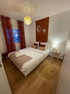 a bedroom with a large white bed in a room at Appartement proche Disneyland in Coulommiers