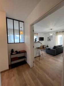 a living room with a couch and a table at Appartement proche Disneyland in Coulommiers
