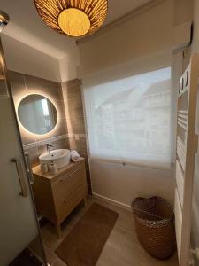 a bathroom with a sink and a large window at Appartement proche Disneyland in Coulommiers