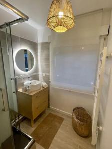 ein Bad mit einem Waschbecken und einem Spiegel in der Unterkunft Appartement proche Disneyland in Coulommiers