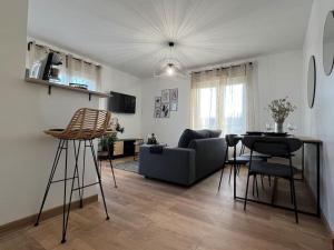 a living room with a couch and a table at Appartement proche Disneyland in Coulommiers +14 photos
