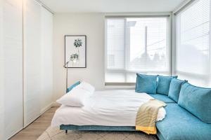 a living room with a blue couch and a bed at NEW! Stylish Townhome in Ballard in Seattle