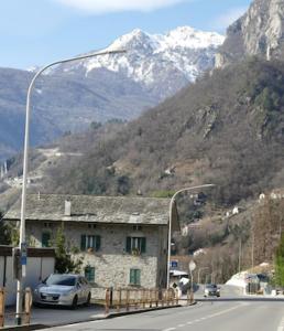 un éclairage de rue avec un bâtiment et une montagne dans l'établissement La pigna, à Chiavenna