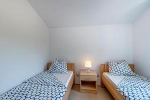 內里吉恩的住宿－Laguna，一间卧室配有两张床和一个带灯的床头柜