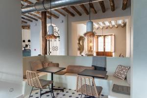 a restaurant with two tables and chairs in a room at Hostal Aljibe in Archidona