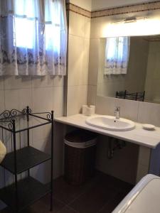 uma casa de banho com um lavatório e um espelho em An all comforts home em Koroni
