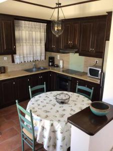 a kitchen with a table and chairs and a kitchen with a table and a kitchen at An all comforts home in Koroni