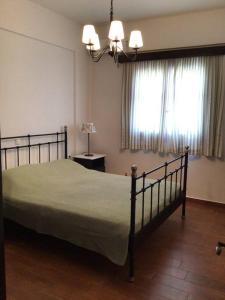 a bedroom with a large bed and a window at An all comforts home in Koroni