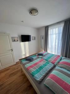 1 dormitorio con 1 cama y TV en Villa Lena - Wohnung Perlmutt, en Ostseebad Sellin