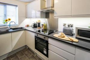 a kitchen with white cabinets and a counter top at 2 Bed Townhouse with Free Parking in Nottingham