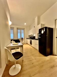 a kitchen with a table and a black refrigerator at Corso Lodi Apartment in Milan