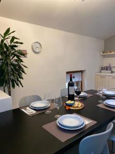 a dining room table with a bottle of wine and glasses at Antica Dimora in Levico Terme