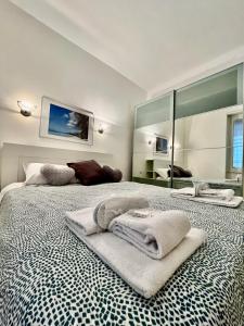 a bedroom with two beds with towels and a mirror at Corso Lodi Apartment in Milan