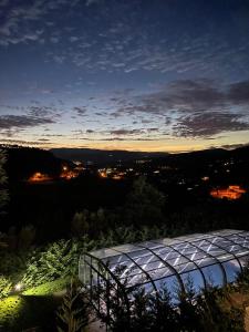 a greenhouse at night with a view of a city at Quintinha da Cachadinha in Ponte de Lima