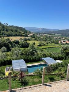 a house with a swimming pool in a field at Quintinha da Cachadinha in Ponte de Lima
