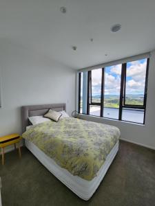 um quarto com uma cama e uma grande janela em Stay Max Apartment for Perfect Short Stay em Auckland