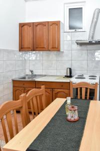 - une cuisine avec une table en bois et des verres dans l'établissement Apartment Studenac, à Banja Luka