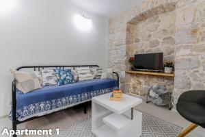 a bedroom with a blue bed and a stone wall at Valentina Apartments Vodice in Vodice