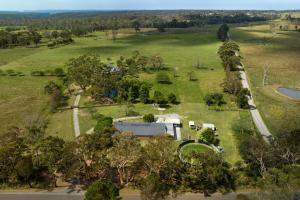 an aerial view of a field with a house and a road at Fentons Run High Range in Joadja Creek