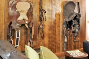 a wall with various saddles and shoes hanging on it at Fentons Run High Range in Joadja Creek