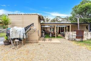 a house with a horse standing outside of it at Fentons Run High Range in Joadja Creek