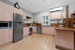 a large kitchen with wooden floors and stainless steel appliances at Fentons Run High Range in Joadja Creek