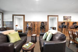 a living room with two leather couches and a table at Fentons Run High Range in Joadja Creek