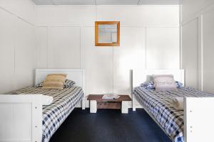 a room with two beds and a table in it at Fentons Run High Range in Joadja Creek