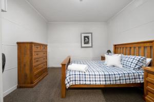 a bedroom with a bed and a dresser in it at Fentons Run High Range in Joadja Creek