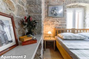 ein Schlafzimmer mit einem Bett und einer Steinmauer in der Unterkunft Valentina Apartments Vodice in Vodice