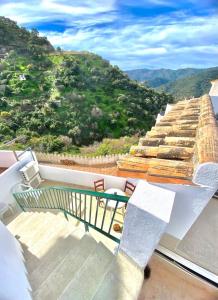 d'un balcon avec un banc et une vue sur la montagne. dans l'établissement Casa Rural Manantial de las Jaras, à Istán
