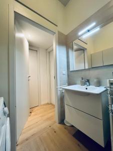 a bathroom with a white sink and a door at Corso Lodi Apartment in Milan