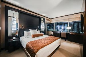 a bedroom with a large bed and a desk and a room with a desk at StripViewSuites at Vdara in Las Vegas