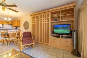 a living room with a television and a kitchen at Hale Kamaole 158 in Wailea