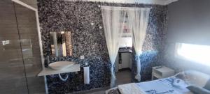 y baño con lavabo y ducha con espejo. en Latorre jacuzzi jerez, en Jerez de la Frontera