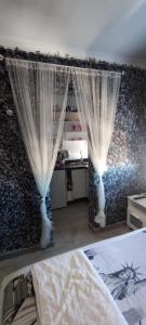 1 dormitorio con 1 cama con cortinas en la pared en Latorre jacuzzi jerez, en Jerez de la Frontera