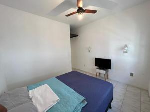 a bedroom with a blue bed and a ceiling fan at Pousada Linda In Ipanema in Rio de Janeiro