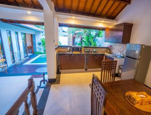 a kitchen and dining room with a table and chairs at Alam Jepun Villa in Legian